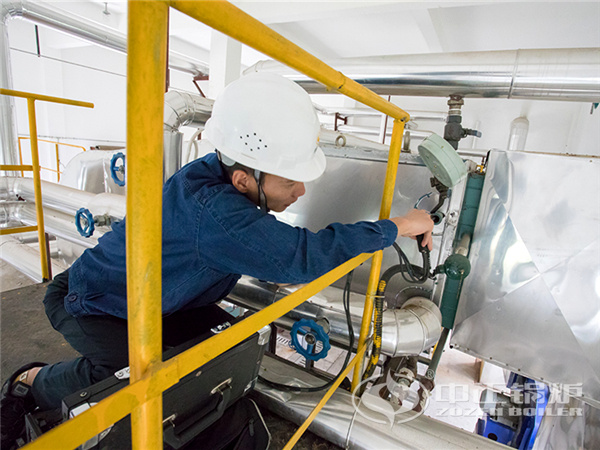 يقوم موظفو خدمة المراجل في شركة زوزان بإجراء عملية الكشف عن غاز المداخن في الغلاية